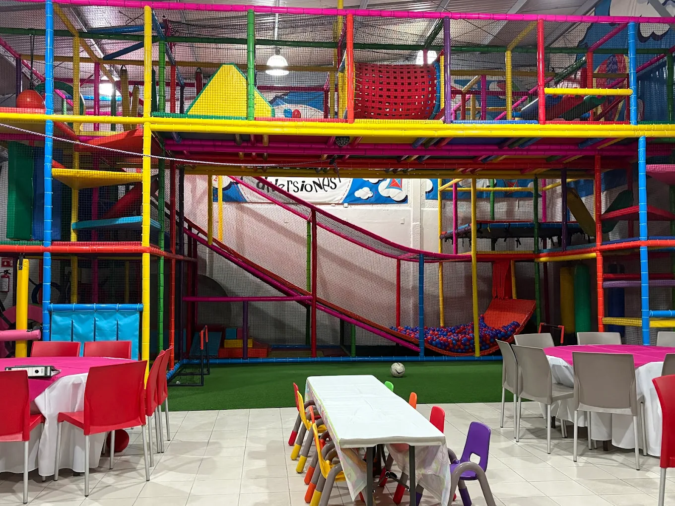 Salón Kanegú con área de juegos coloridos y mesas decoradas para fiesta infantil